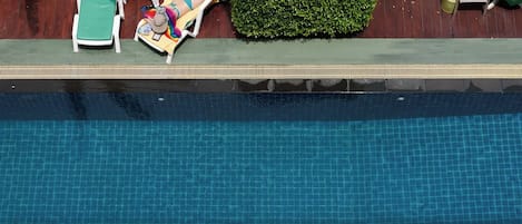 Una piscina con borde de azulejos y una banda verde.