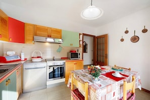 Una cocina equipada con lavavajillas, estufa, microondas y armarios de madera.