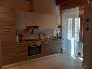 Une cuisine moderne avec des meubles en bois, une cuisinière à gaz, un four et un évier.