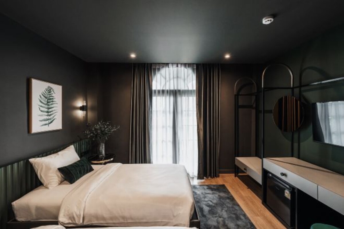 A modern bedroom with a bed, bedside table, and a TV.