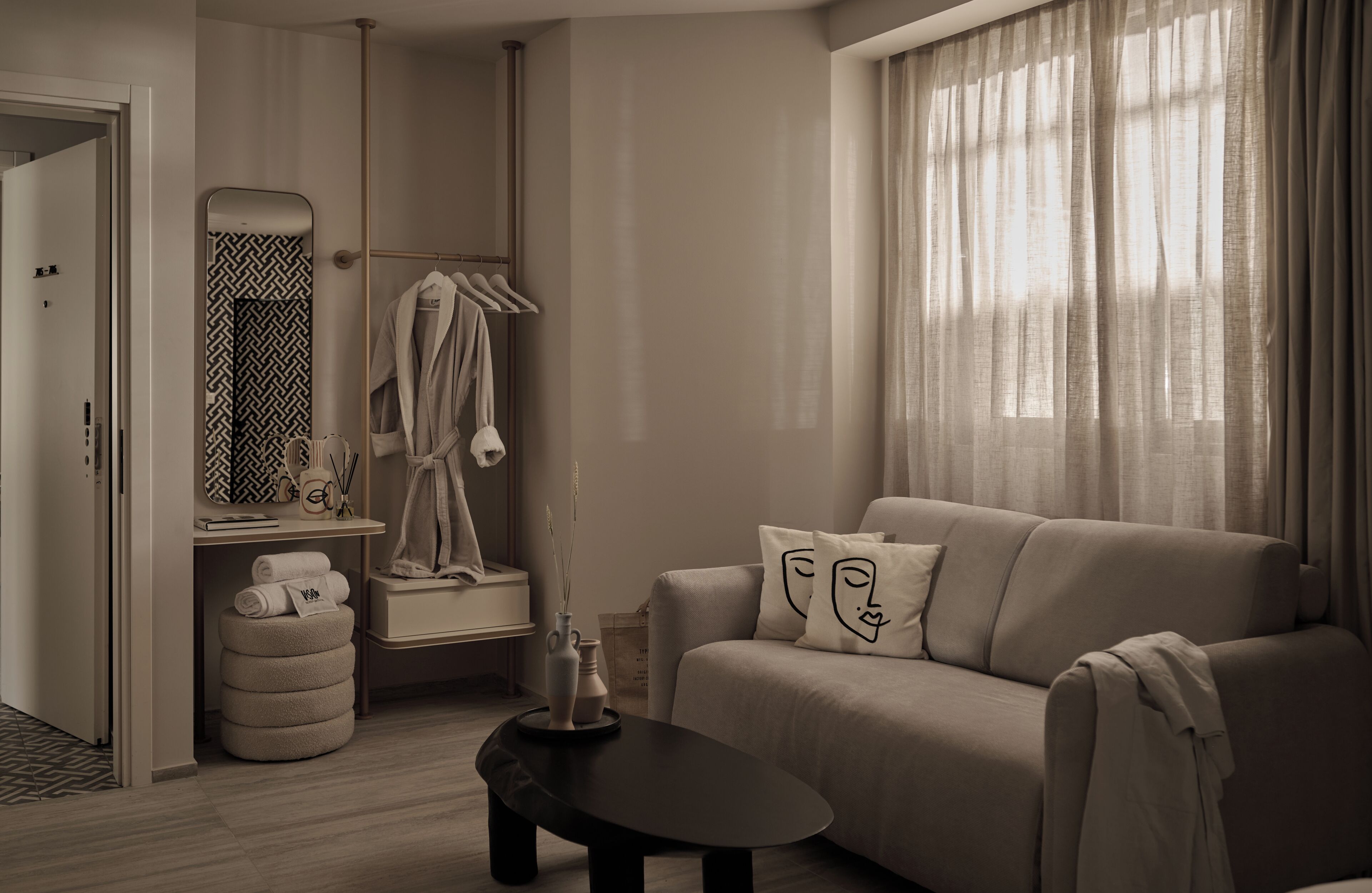 A modern, neutral-toned living room with a sofa, a coffee table, and a mirror.