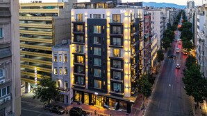 Un hôtel à plusieurs étages doté de balcons, d’un parking souterrain et donnant sur la rue.