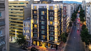 A multi-story hotel with balconies, a parking garage, and a street view.