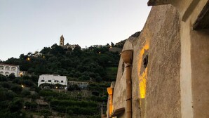 A pathway with a railing, leading to a building with a bell tower. - Alma Domus ancient house recently opened in Amalfi (Amalfi)