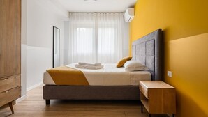 Une chambre à coucher moderne avec un lit, une table de chevet et une armoire.
