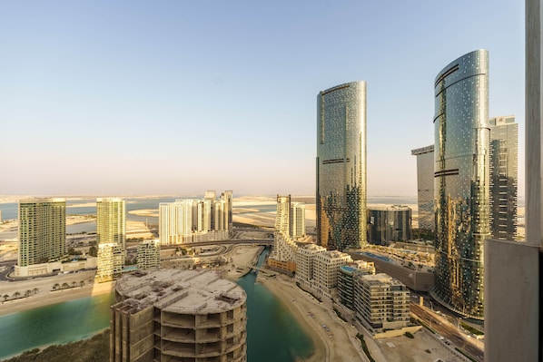 A high-rise urban area with modern skyscrapers, a marina, and a river.
