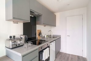 A modern kitchen with a built-in oven, a stovetop, and a sink.