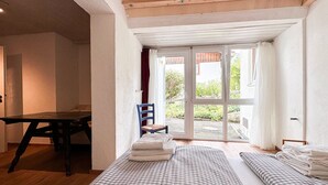 Een kamer met twee bedden, een houten tafel en een stoel.