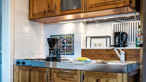 Eine Küche mit Holzausstattung, einer Kaffeemaschine und einer Mikrowelle.