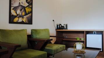 A modern living area with a sofa, a coffee table, and a small refrigerator.