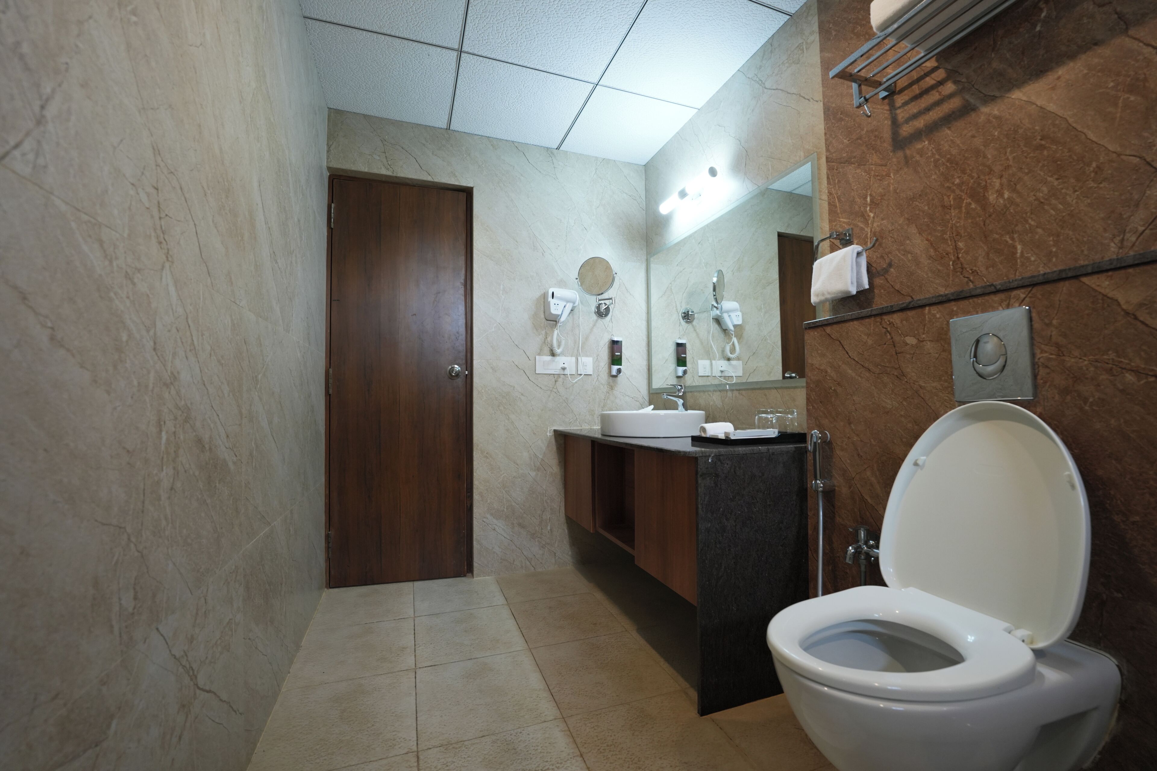 A modern bathroom with a toilet, sink, and mirror.
