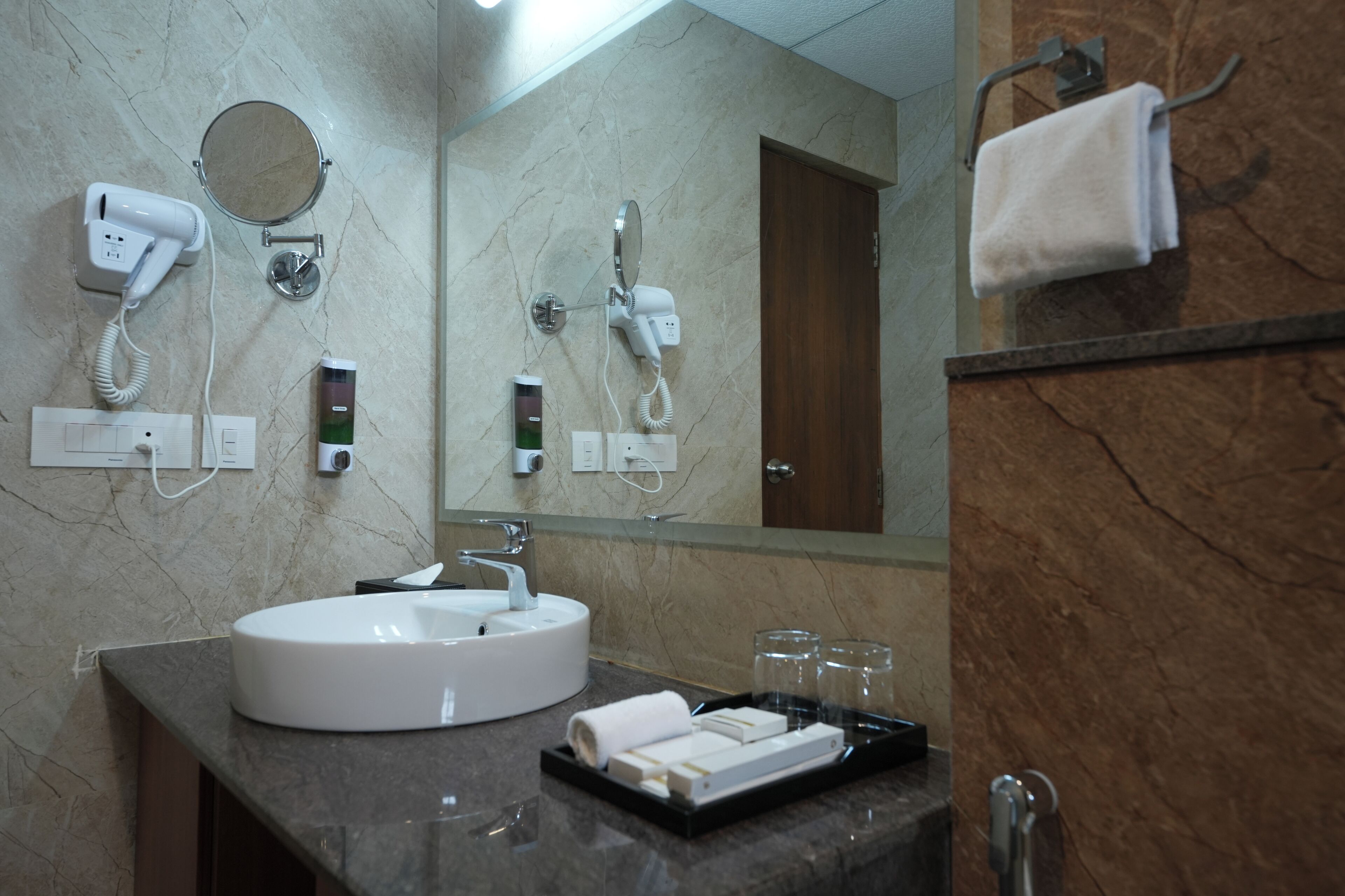 Un baño con lavamanos, perchero para toallas y secador de pelo.