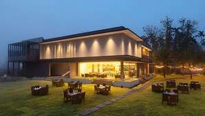 A modern building with a spacious outdoor seating area and a well-lit entrance. - Malnad Shire (Shimoga)
