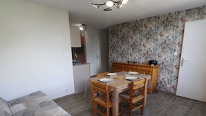 Ein kompakter Wohnbereich mit Essplatz, Küchenzeile und Sofa.