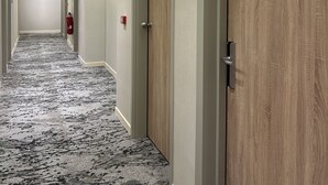 A hotel corridor with wooden doors, numbered 408, and a fire extinguisher on the wall. - Hôtel Oden Paris Ivry (Ivry-sur-Seine)