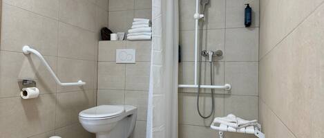 Un baño moderno con inodoro, ducha y barras de apoyo.