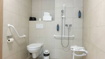 Une salle de bain moderne équipée de toilettes, d’un bidet et d’une douche.