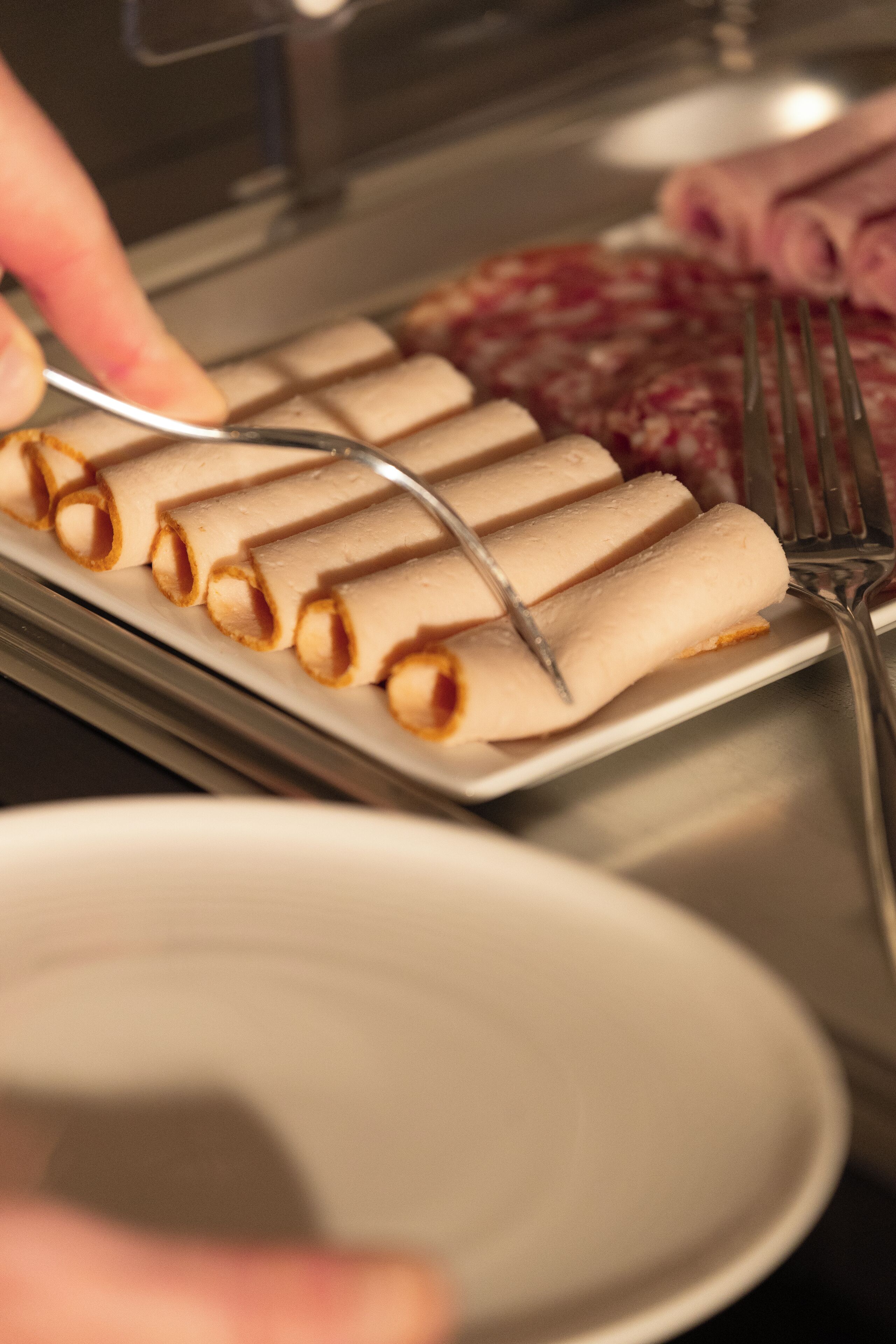 Une assiette de viennoiseries roulées, accompagnée d’une fourchette.