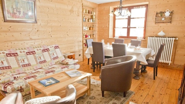 A cozy log cabin interior with a living room, dining area, and a bookshelf. - Spacious 3-room apartment with Wi-Fi and parking in Saint-Chaffrey (Saint-Chaffrey)
