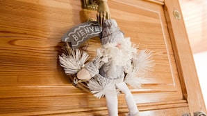 A wooden door with a welcome sign and a decorative figure. - Spacious 3-room apartment with Wi-Fi and parking in Saint-Chaffrey (Saint-Chaffrey)