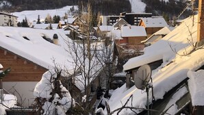 A snowy village with traditional wooden houses and a ski slope in the background. - Spacious 6-Room Chalet for 10, Private Garden, Near Serre Chevalier Pistes (La Salle-les-Alpes)