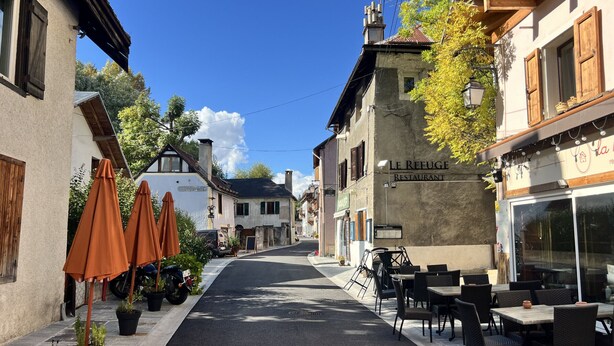 A street with outdoor seating, a restaurant named 'Le Refuge Restaurant,' and traditional European architecture. - Spacious 6-Room Chalet for 10, Private Garden, Near Serre Chevalier Pistes (La Salle-les-Alpes)