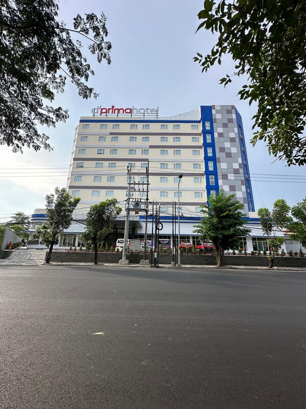 A multi-story hotel with a blue and white facade, featuring a prominent 'diorima hotel' sign.