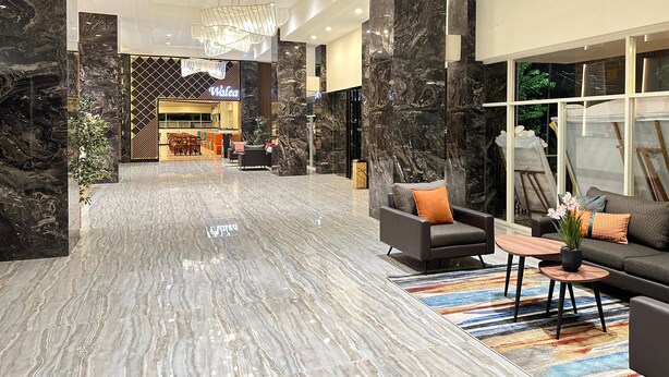A spacious lobby with marble flooring, modern furniture, and a Walea sign in the background. - d'primahotel Jemursari Surabaya (Surabaya)