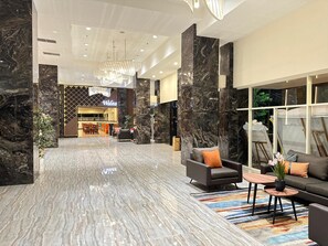 A spacious lobby with marble flooring, modern furniture, and a Walea sign in the background.