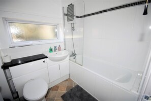 A bathroom with a toilet, sink, and bathtub.