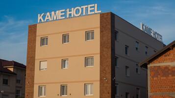A multi-story hotel building with the name "KAME HOTEL" prominently displayed on the facade.