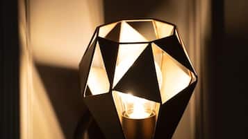 A geometric-patterned wall sconce emitting warm light.