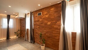 A modern hotel room with a wooden wall, large windows with curtains, a potted plant, and a small air conditioning unit. - KAME HOTEL BELGRADE (Belgrade)
