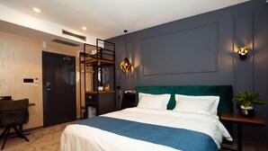 A modern hotel room with a large bed, a desk, a chair, and a small table with a plant. - KAME HOTEL BELGRADE (Belgrade)