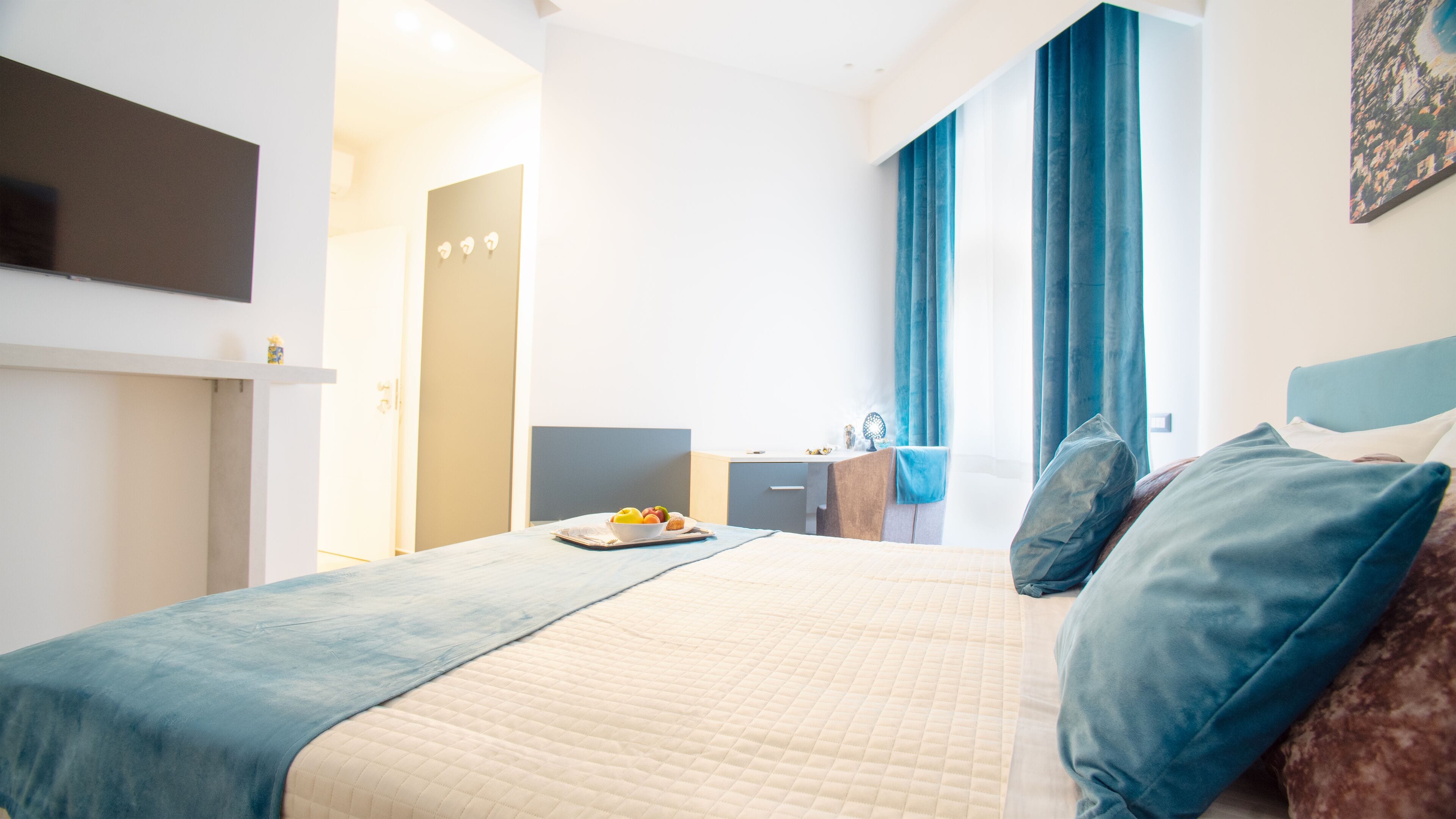 Ein Hotelzimmer mit einem Bett, einem Schreibtisch und einem Fernseher.