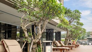 A rooftop lounge area with lounge chairs and a trash bin. - Karaton by Kozystay (Bandung)