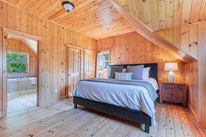 A wooden-paneled bedroom with a bed, bedside table, and a window. - Fiddler Lake Resort - Moose 46 (Mille-Isles)