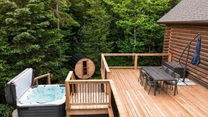 A wooden deck with a hot tub, a sauna, and a dining area with outdoor furniture. - Fiddler Lake Resort - Rabbit 57 (Mille-Isles)