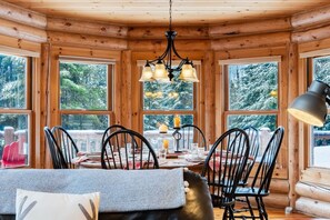 A wooden cabin interior with a dining table, chairs, and a chandelier. - Fiddler Lake Resort - Rabbit 57 (Mille-Isles)