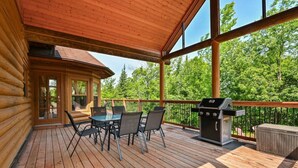A wooden deck with a table and chairs, a grill, and a view of trees. - Fiddler Lake Resort - Deer 86 (Mille-Isles)