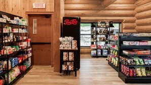 Un magasin dont les étagères sont remplies d’en-cas et qui possède un réfrigérateur rempli de boissons Pepsi.