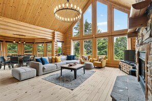 Ein großzügiger Wohnbereich mit einer großen Couch, Sesseln, einem Couchtisch und einem Kamin.
