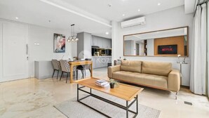 Una sala de estar moderna con un sofá, una mesa de centro y una zona de comedor con sillas y una mesa.