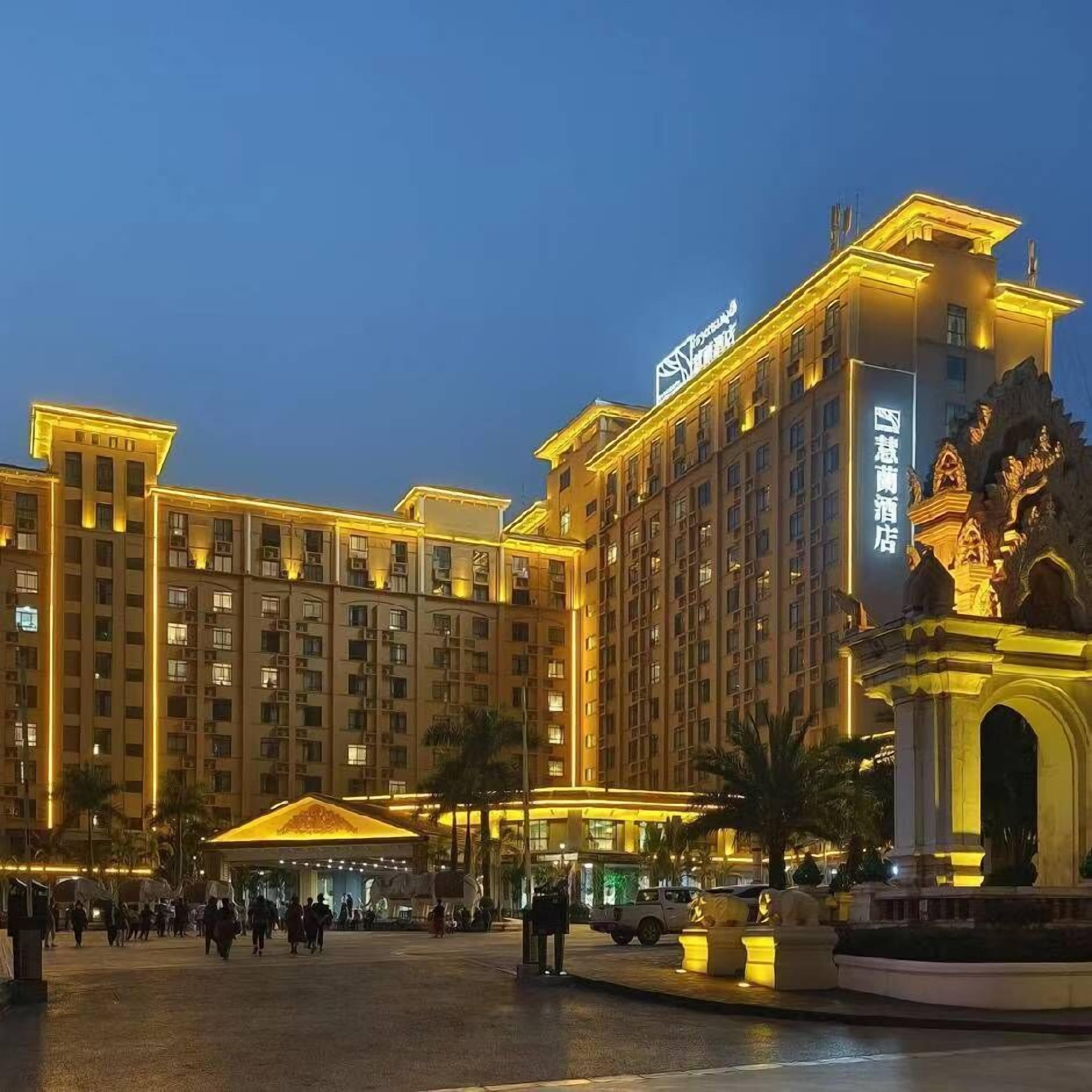 A large hotel with multiple floors, a central courtyard, and a statue.
