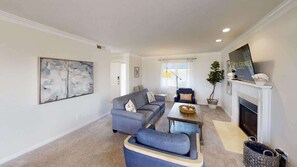 A living room with a sofa, a coffee table, and a fireplace. - Las Palmas Resort #201 | All-Inclusive Amenities (Saint George)