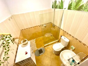 Ein kleines Badezimmer mit Dusche, Toilette und Waschbecken.