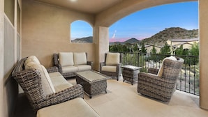 A balcony with wicker furniture, a view of hills, and a clear sky. - Luxury Oasis Heated Pool & Spa* - 7BR Luxury Estate w/ Panoramic Mountain Views! (Mesa)