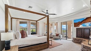 A spacious bedroom with a four-poster bed, a ceiling fan, and a view of mountains through large windows. - Luxury Oasis Heated Pool & Spa* - 7BR Luxury Estate w/ Panoramic Mountain Views! (Mesa)