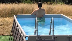 A person in a swimming pool with a ladder and a chair. - Functional Mini Luxury Lodges Near Camerino (Camerino)
