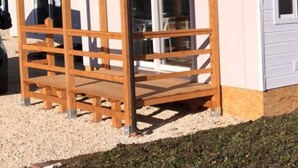A small, single-story building with a wooden porch and a glass door. - Functional Mini Luxury Lodges Near Camerino (Camerino)